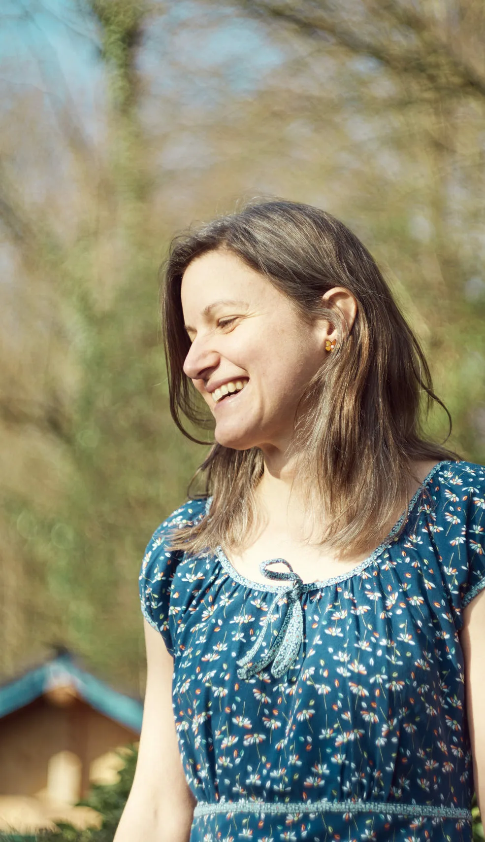 Nicole in der Natur im Profil und lacht